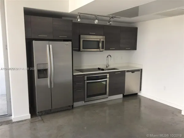 a kitchen with stainless steel appliances a stove a microwave and a refrigerator