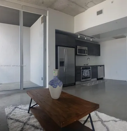 a living room with a table and a potted plant