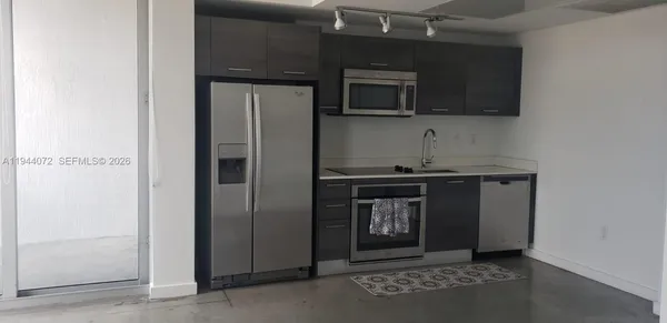 a kitchen with stainless steel appliances granite countertop a refrigerator and a stove top oven
