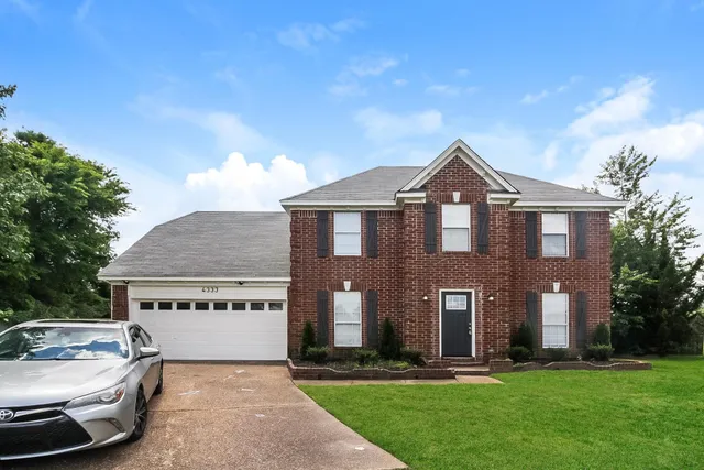 a front view of a house with a yard and garage