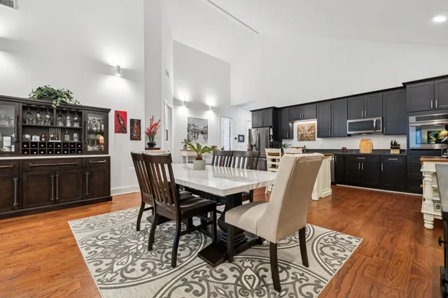a dining area with stainless steel appliances kitchen island granite countertop a dining table and chairs