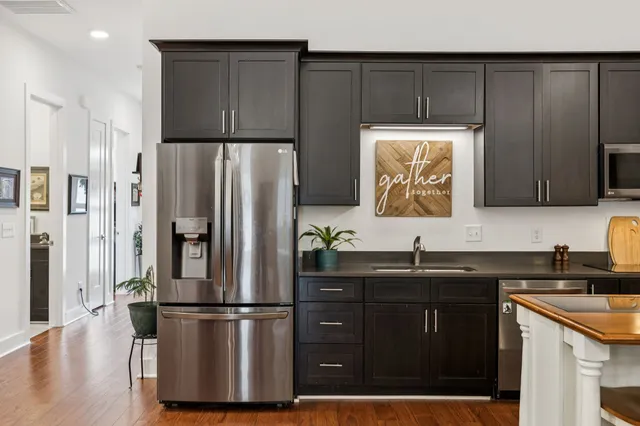 a kitchen with a sink a refrigerator and cabinets