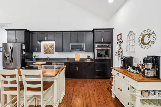 a large kitchen with cabinets wooden floor and stainless steel appliances