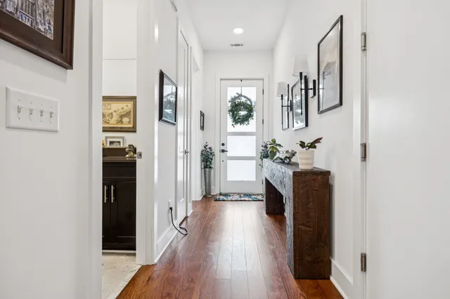 a view of a hallway with wooden floor and windows