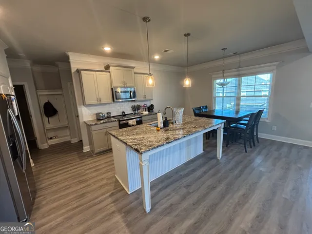 a kitchen with stainless steel appliances granite countertop a stove refrigerator and a refrigerator