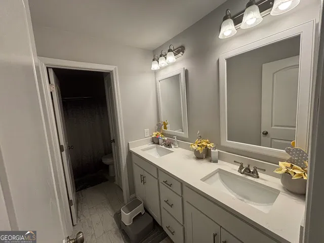 a bathroom with a double vanity sink and mirror