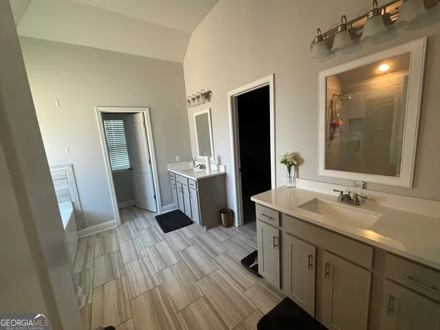 a spacious bathroom with a double vanity sink and a mirror