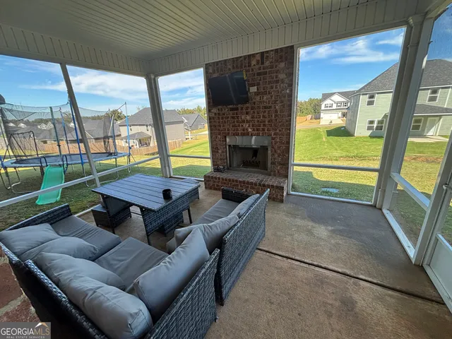 a living room with furniture a flat screen tv and a floor to ceiling window