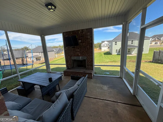 a view of a patio with a dining table and chairs with a barbeque grill