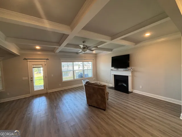 a living room with hard wood floors and a kitchen