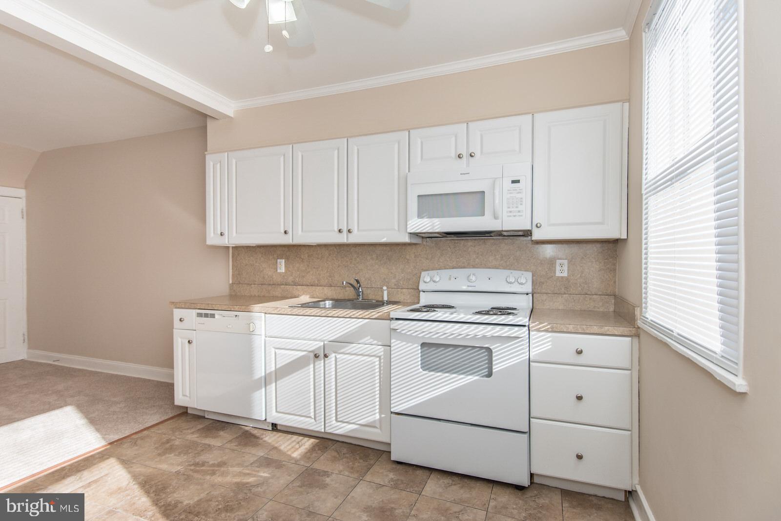 7119 Gillespie Street Philadelphia, PA 19135 - Photo 12 of 47 a kitchen with cabinets appliances a sink and a window
