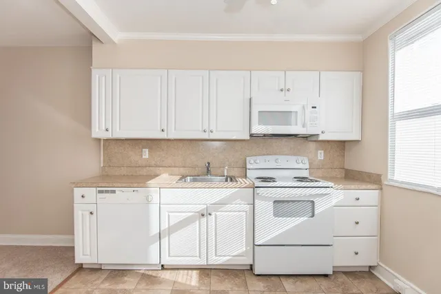 a kitchen with a sink a window and cabinets