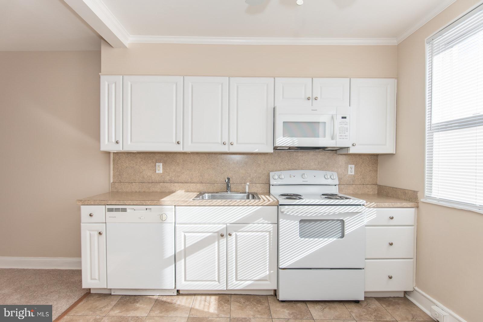 7119 Gillespie Street Philadelphia, PA 19135 - Photo 13 of 47 a kitchen with white cabinets and white appliances