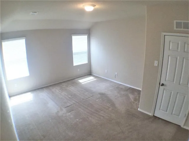 a view of an empty room and wooden floor