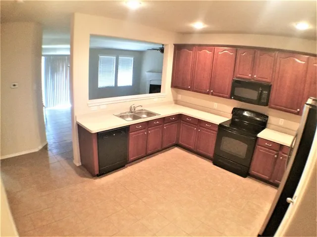 a kitchen with stainless steel appliances granite countertop a refrigerator stove a sink and dishwasher