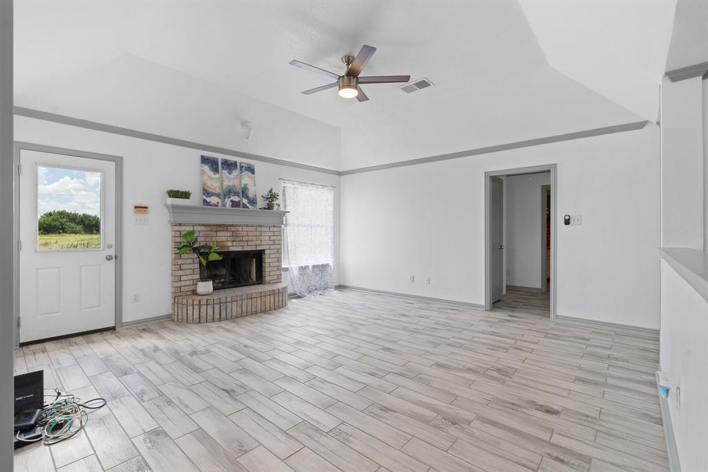 2600 Dave Angel Road Burleson, TX 76028 - Photo 13 of 33 a view of an empty room with wooden floor a fireplace and a window