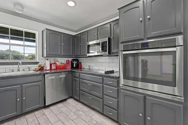 a kitchen with stainless steel appliances granite countertop a sink and cabinets