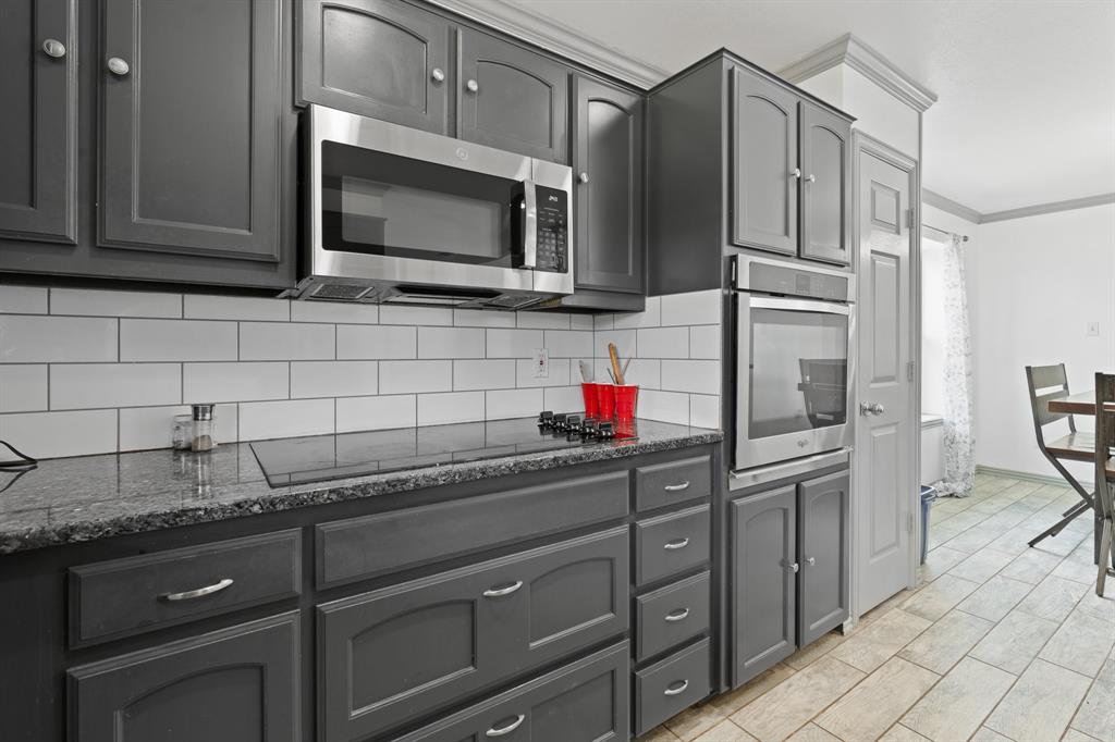 2600 Dave Angel Road Burleson, TX 76028 - Photo 16 of 31 a kitchen with stainless steel appliances granite countertop a sink stove and microwave