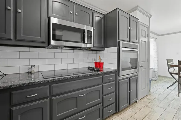a kitchen with stainless steel appliances granite countertop a sink stove and microwave