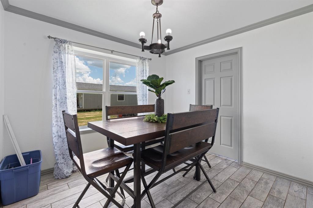 2600 Dave Angel Road Burleson, TX 76028 - Photo 19 of 31 a dining room with furniture wooden floor a chandelier and a rug