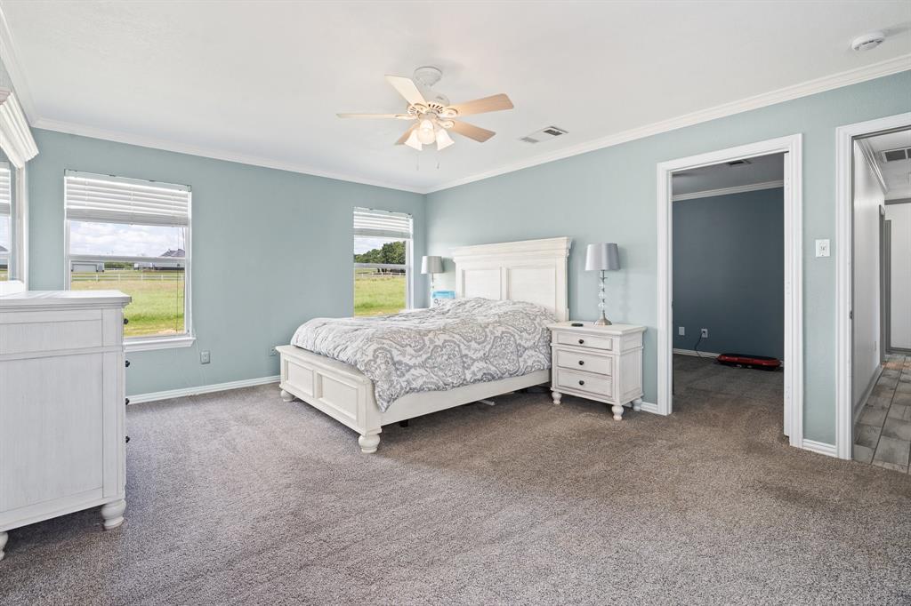 2600 Dave Angel Road Burleson, TX 76028 - Photo 22 of 33 a spacious bedroom with a bed and a chandelier
