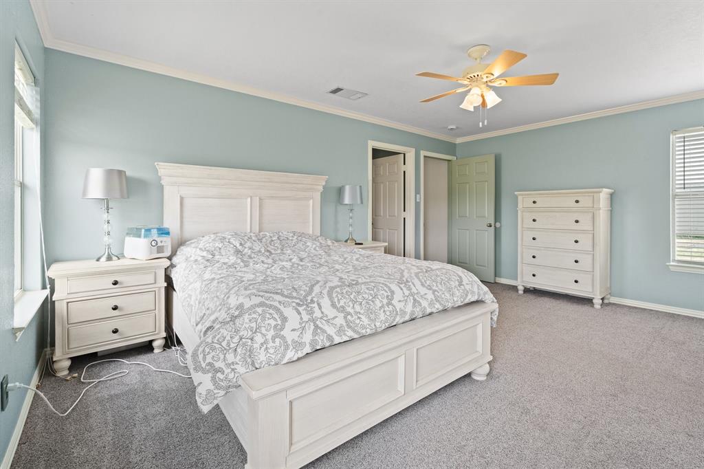 2600 Dave Angel Road Burleson, TX 76028 - Photo 23 of 33 a spacious bedroom with a bed and a chandelier