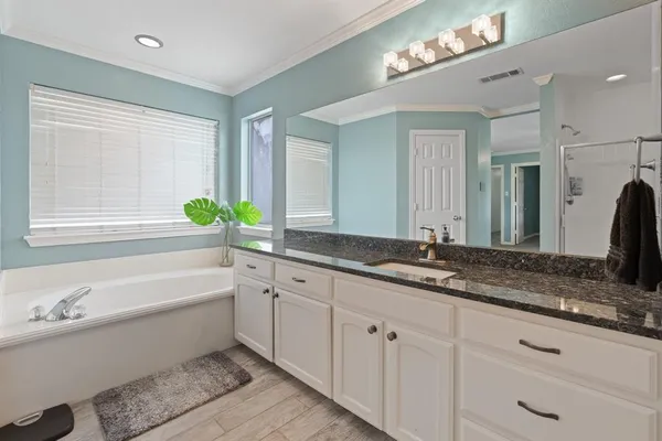 a bathroom with a granite countertop sink mirror and bathtub
