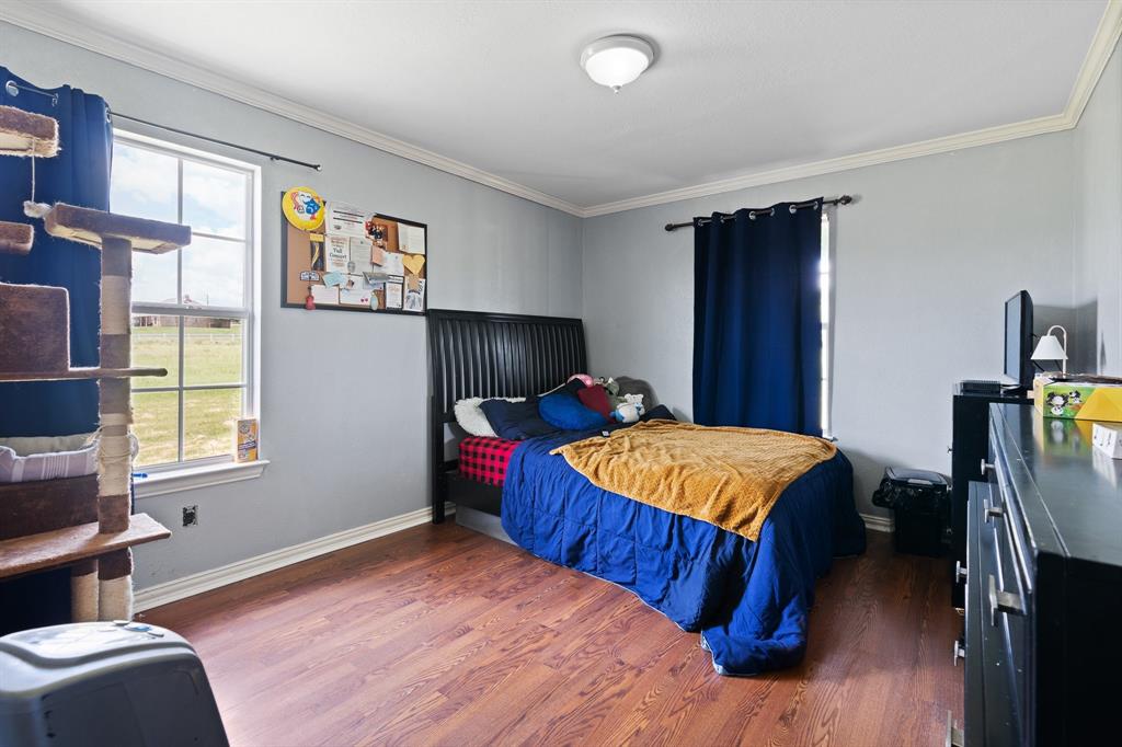 2600 Dave Angel Road Burleson, TX 76028 - Photo 28 of 31 a bed sitting in a bedroom next to a window