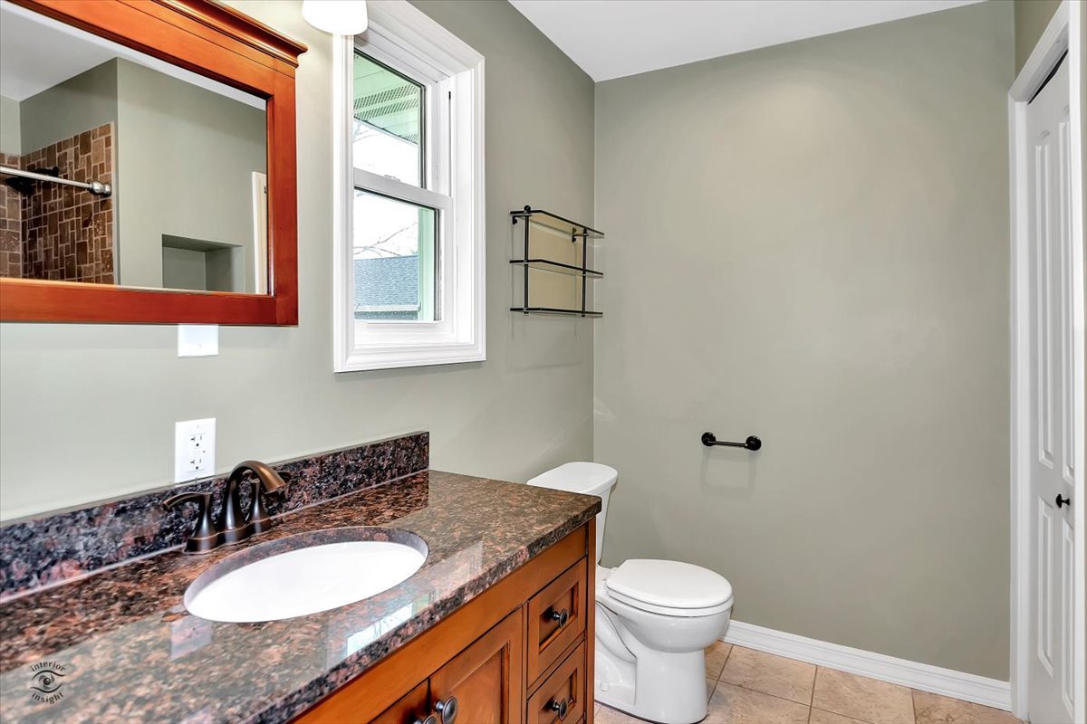 302 North Raven Road Shorewood, IL 60404 - Photo 12 of 26 a bathroom with a granite countertop toilet a sink and a mirror