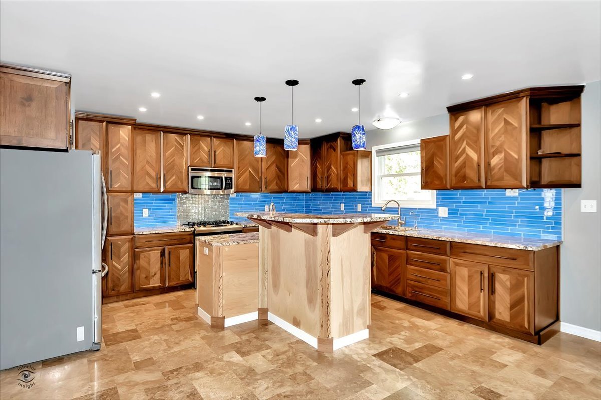 302 North Raven Road Shorewood, IL 60404 - Photo 6 of 26 a kitchen with stainless steel appliances granite countertop wooden cabinets a granite counter top and a sink