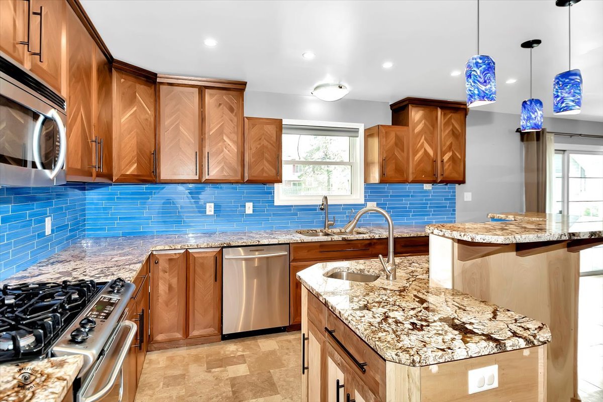 302 North Raven Road Shorewood, IL 60404 - Photo 7 of 26 a kitchen with stainless steel appliances granite countertop a stove a sink and a microwave