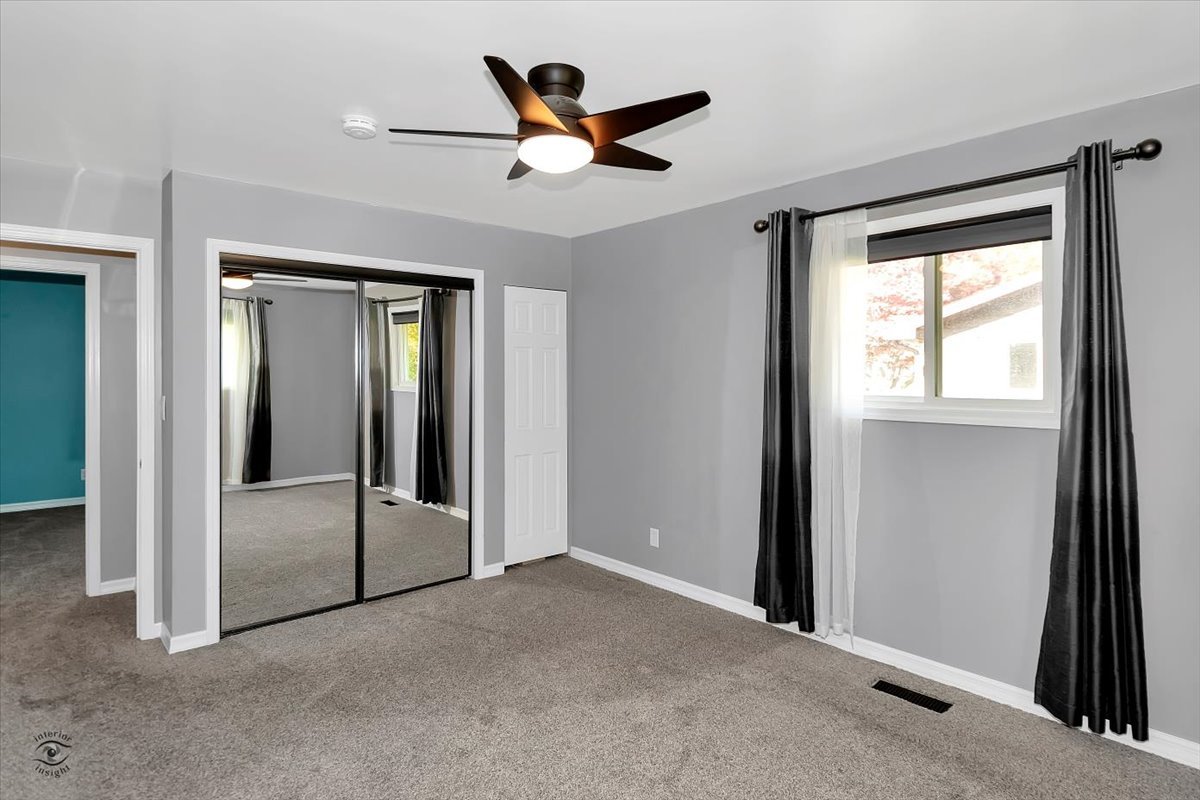 302 North Raven Road Shorewood, IL 60404 - Photo 10 of 26 a view of a livingroom with a ceiling fan and wooden floor