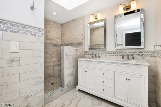 a bathroom with a granite countertop sink two mirror and a