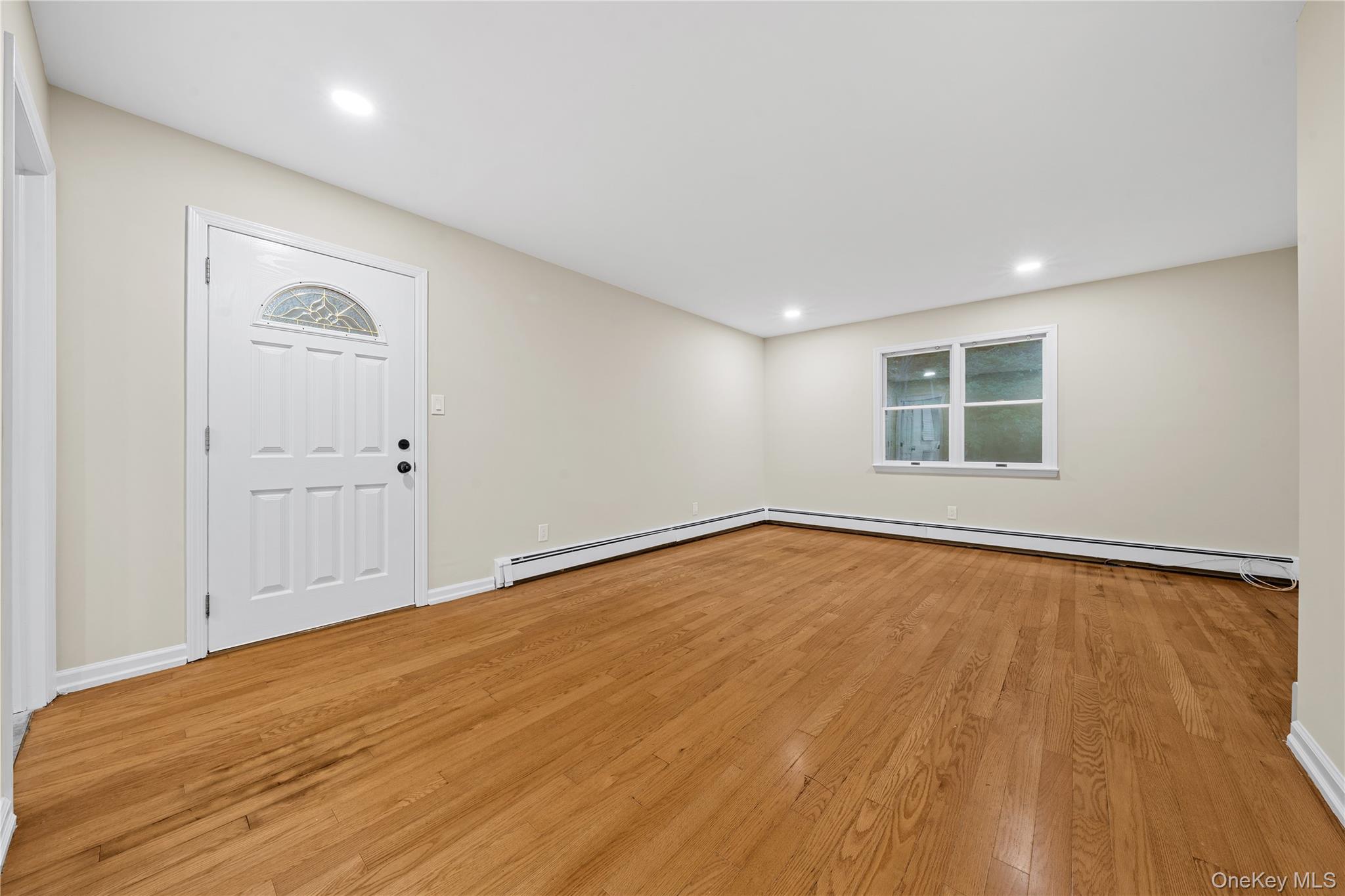 57 Eastwood Road Miller Place, NY 11764 - Photo 16 of 45 an empty room with wooden floor and windows