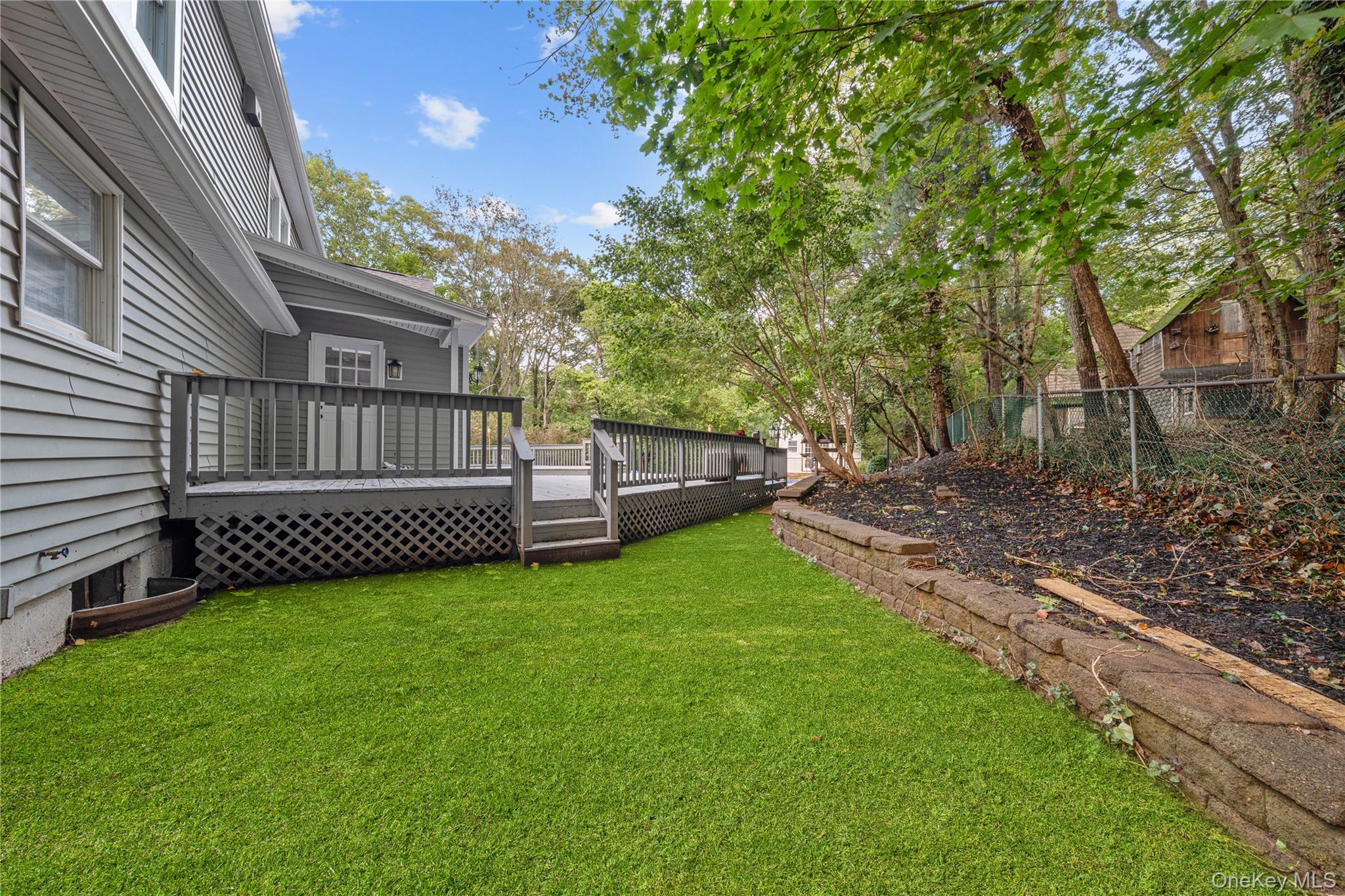 57 Eastwood Road Miller Place, NY 11764 - Photo 31 of 45 a view of a deck with a big yard and large trees