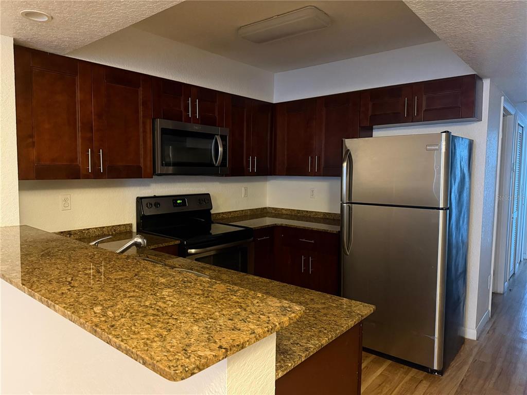 2323 McCoy Road, Unit 815 Orlando, FL 32809 - Photo 13 of 14 a kitchen with a refrigerator sink and microwave