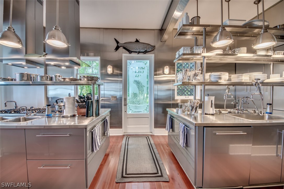 8241 Main Street Bokeelia, FL 33922 - Photo 16 of 35 a kitchen with kitchen island a counter top space a sink stainless steel appliances and cabinets