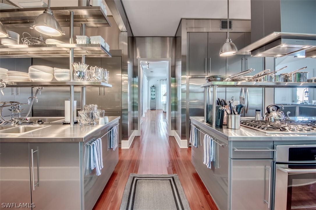 8241 Main Street Bokeelia, FL 33922 - Photo 17 of 35 a kitchen with kitchen island a large counter top space a sink and appliances