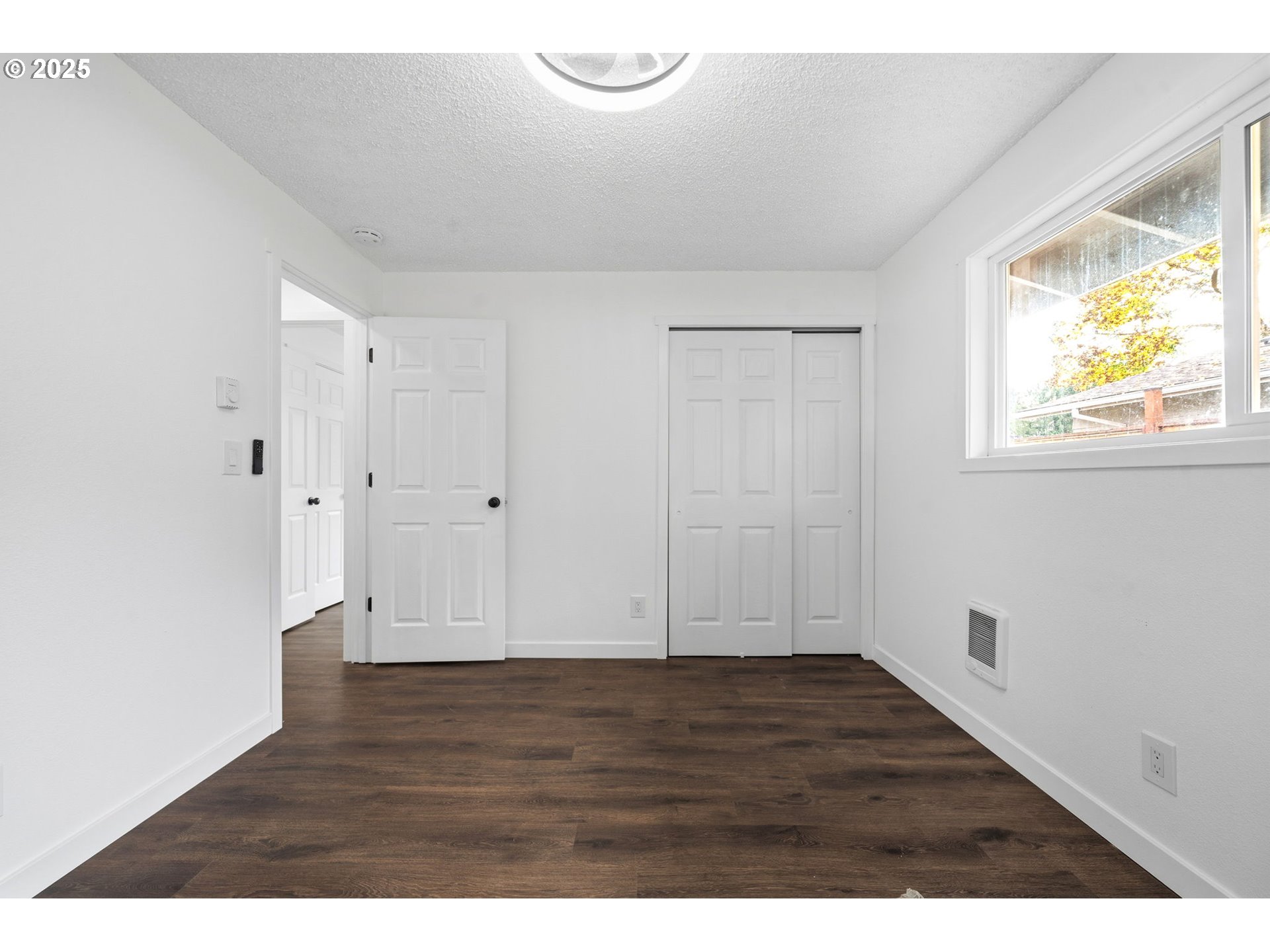 1425 Willamina Avenue Forest Grove, OR 97116 - Photo 12 of 38 a view of an empty room with wooden floor and a window
