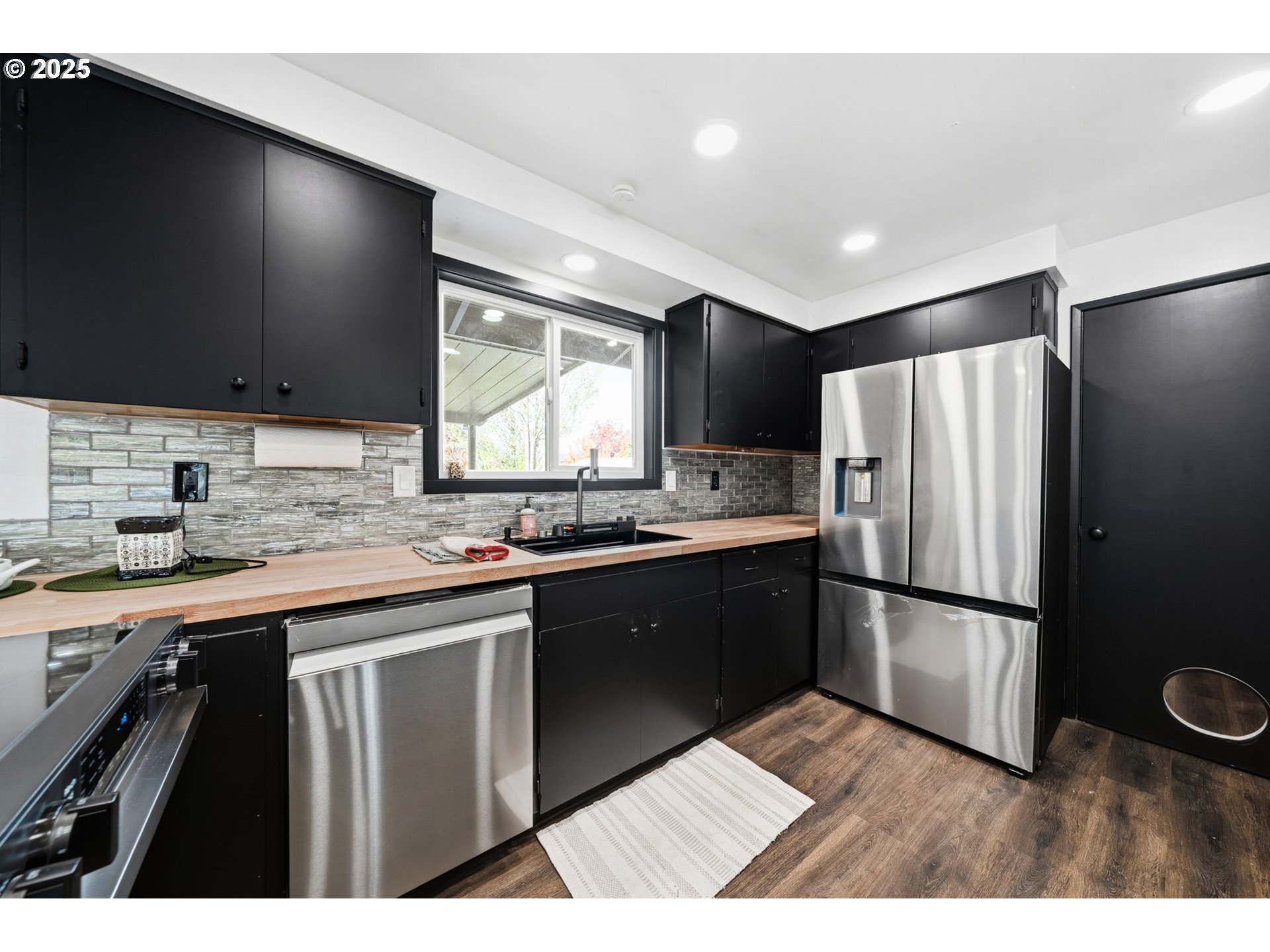 1425 Willamina Avenue Forest Grove, OR 97116 - Photo 8 of 38 a kitchen with stainless steel appliances granite countertop a refrigerator a sink dishwasher a stove and a microwave oven on granite countertops
