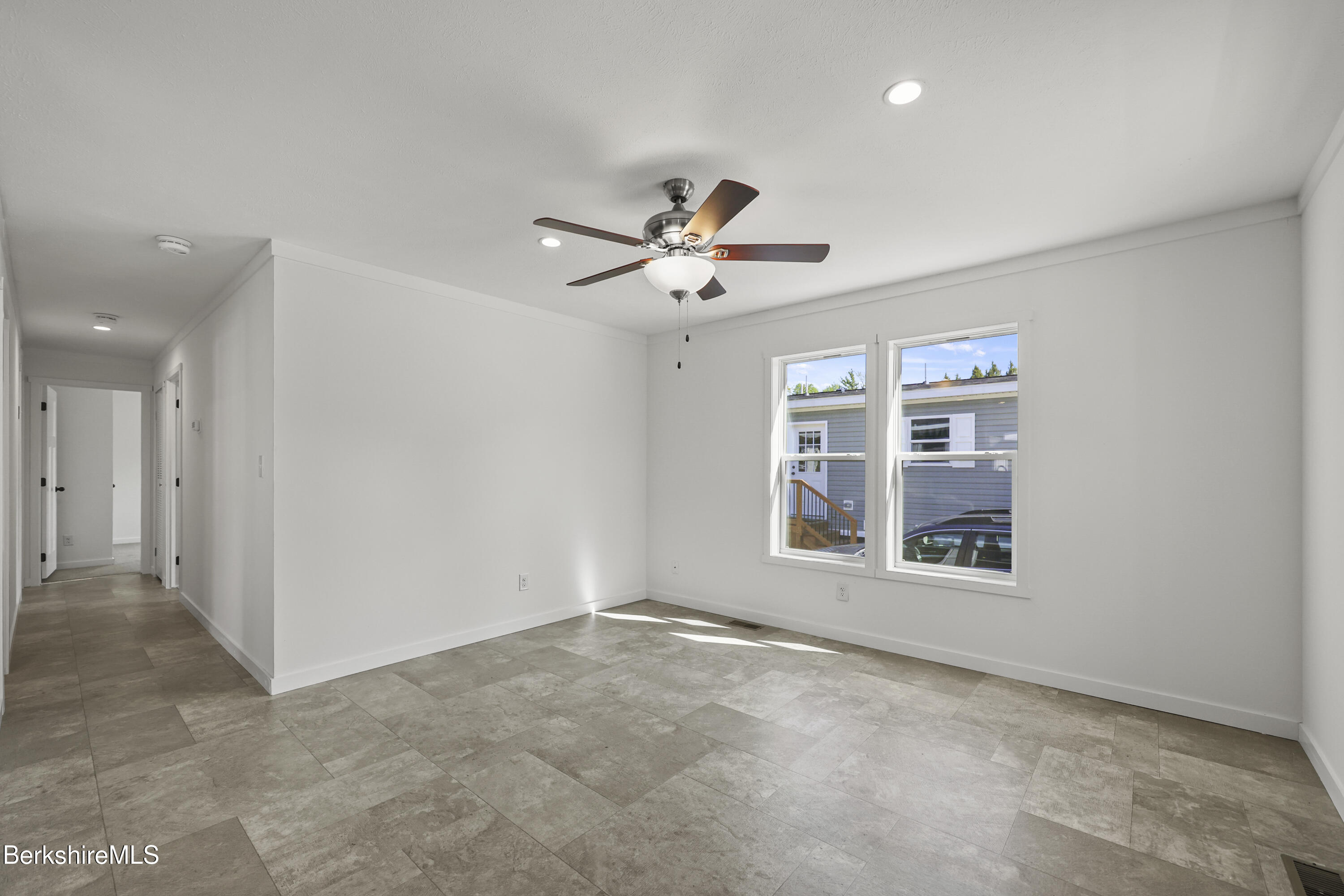 395 Cheshire Road, Unit 102 Pittsfield, MA 01201 - Photo 5 of 28 an empty room with fan and windows