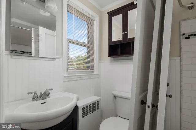 a bathroom with a toilet a sink and mirror