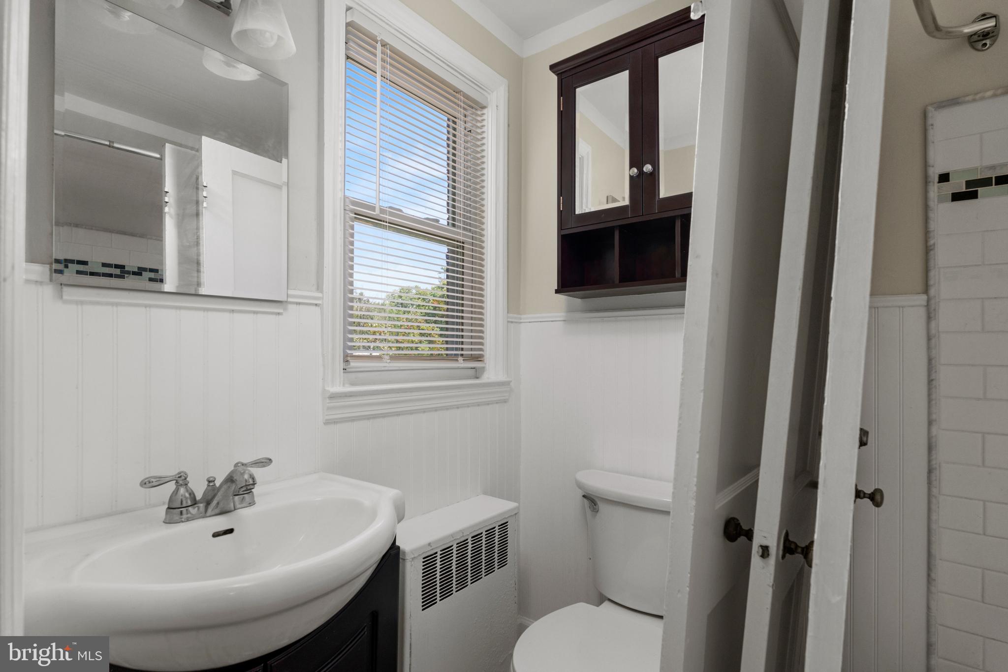 5708 Rockspring Road, Unit B Baltimore, MD 21209 - Photo 11 of 19 a bathroom with a toilet a sink and mirror
