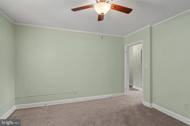 an empty room with a chandelier fan