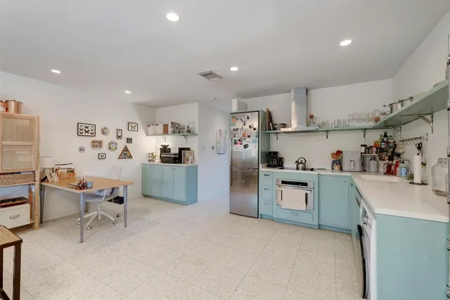 a kitchen with refrigerator and cabinets