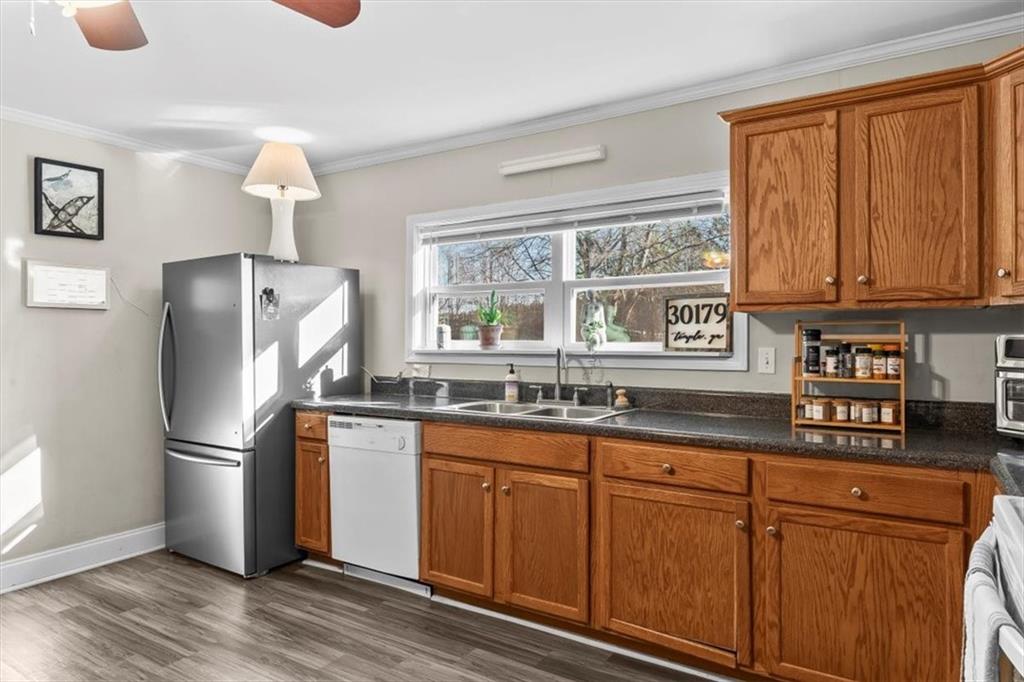 718 Baskin Road Temple, GA 30179 - Photo 13 of 50 a kitchen with granite countertop wooden cabinets a refrigerator and a sink