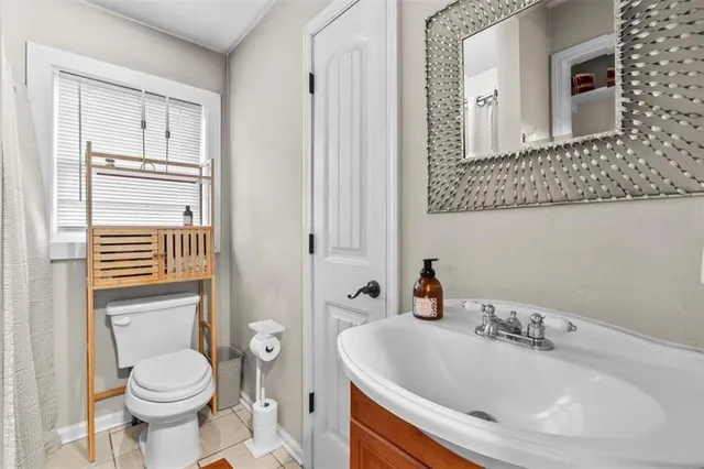 a bathroom with a sink a toilet and a mirror