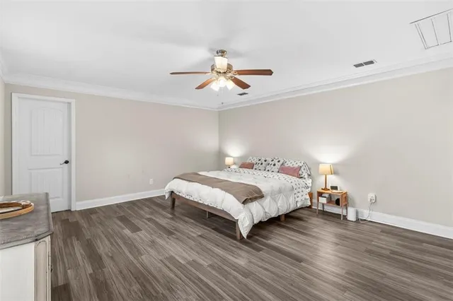 a bedroom with a bed and wooden floor