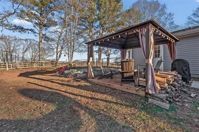 a view of a house with backyard and trees