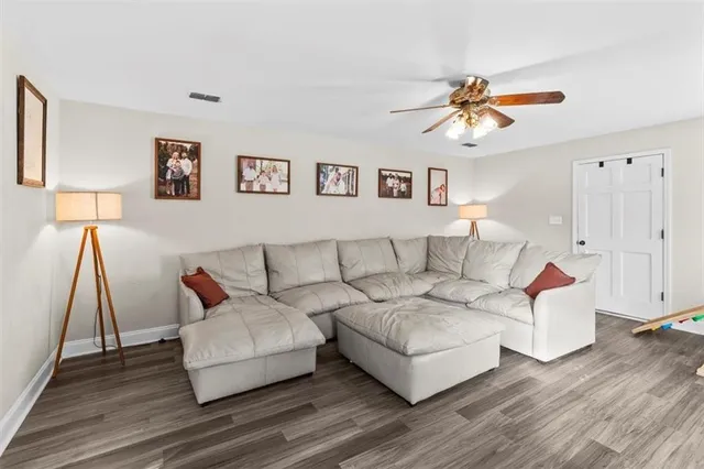 a living room with furniture and a wooden floor